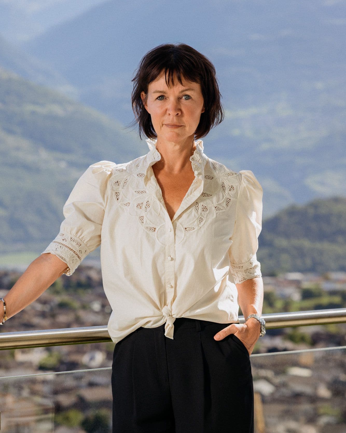 Drsse Hélène Heuninckx, debout sur une terrasse, les montagnes derrière elle
